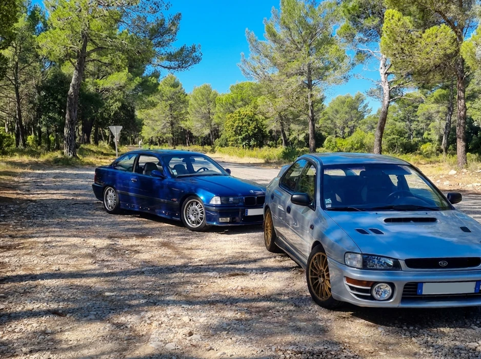 Scène extérieure d'une maison moderne avec garage, voiture blanche stationnée sur béton lissé, ciel bleu dégagé, architecture contemporaine aux lignes épurées